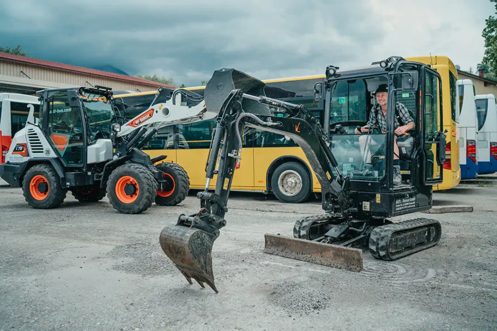 Baumaschinenschein für Erdbaumaschinen, ein Teilnehmer bedient einen Minibagger, daneben steht ein Radlader.
