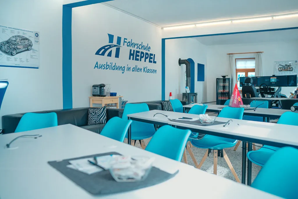 Schulungsraum der Fahrschule Heppel in Oberaudorf mit Wandlogo und Schriftzug Ausbildung in allen Klassen.