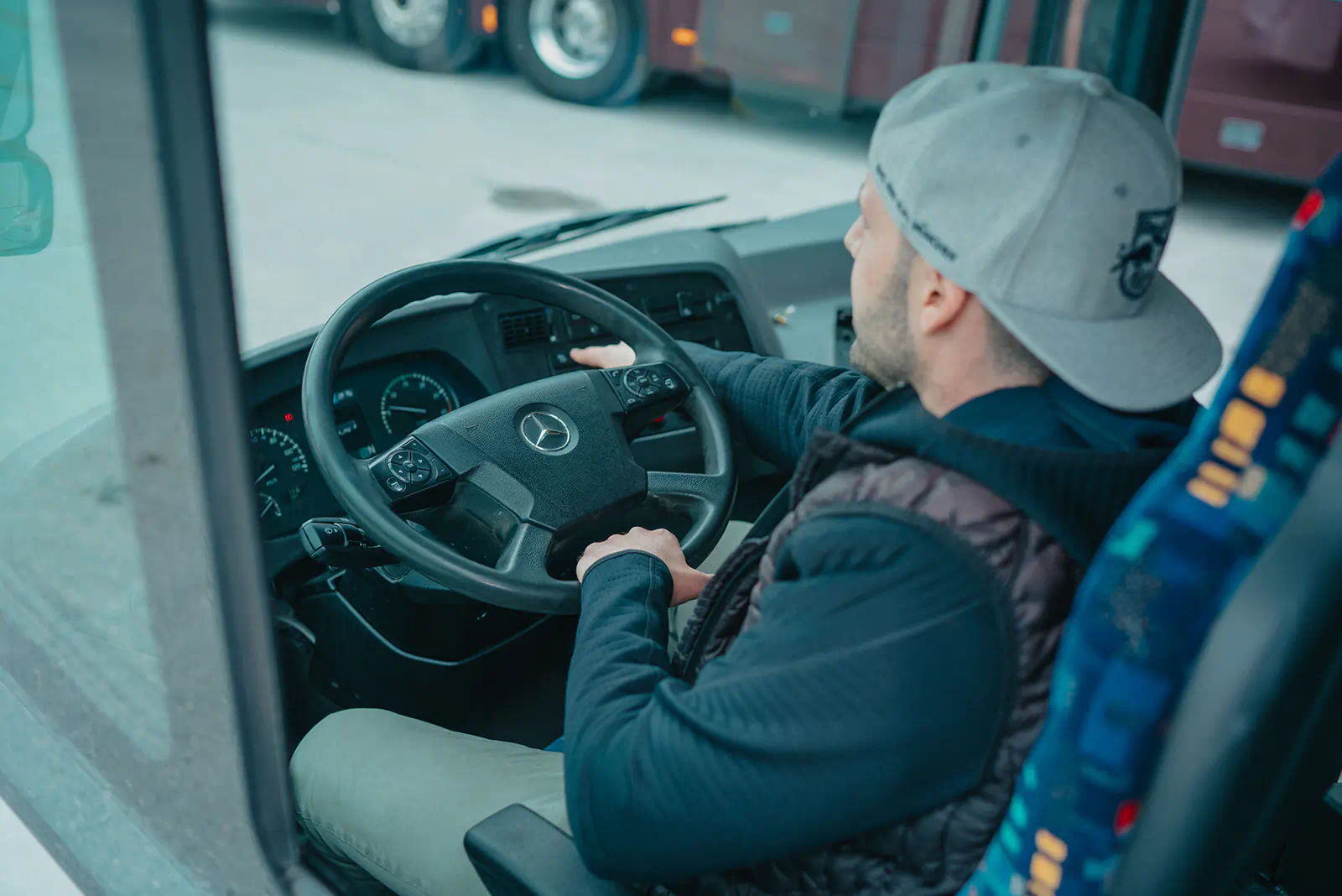 Grundqualifikation Bus, ein Teilnehmer der Fahrschule Heppel am Lenkrad im Fahrerstand eines Busses.